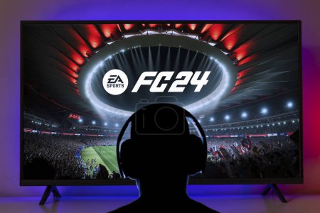 Photo for Man playing EA FC 24 with headphones on TV screen, 24 Jul, 2023, Sao Paulo, Brazil - Royalty Free Image