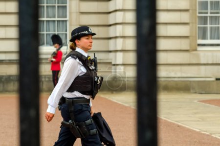 Photo for London, United Kingdom - May 21, 2018 : View of a female police officer in front of the Buckingham Palace in London UK - Royalty Free Image