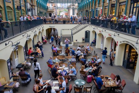 Photo pour Londres, Royaume-Uni : 21 mai 2018 - Vue des touristes assis dans un restaurant à Covent Garden et profitant d'un spectacle humoristique de rue - image libre de droit