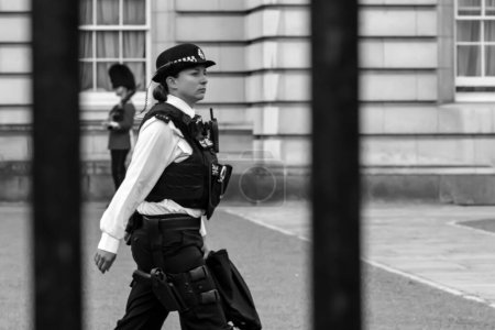 Photo for London, United Kingdom - May 21, 2018 : View of a female police officer in front of the Buckingham Palace in London UK in black and white - Royalty Free Image