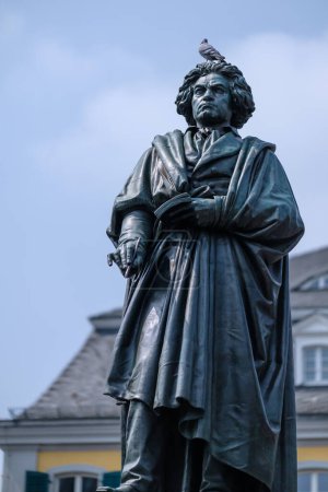 Foto de Bonn, Alemania - 22 de mayo de 2023: Vista de la estatua de Ludwig van Beethoven y una paloma encima de ella en Bonn Alemania - Imagen libre de derechos