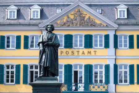 Foto de Bonn, Alemania - 22 de mayo de 2023: Vista de la estatua de Ludwig van Beethoven y el edificio postal alemán en el fondo en Bonn Alemania - Imagen libre de derechos