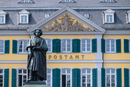 Foto de Bonn, Alemania - 22 de mayo de 2023: Vista de la estatua de Ludwig van Beethoven y el edificio postal alemán en el fondo en Bonn Alemania - Imagen libre de derechos