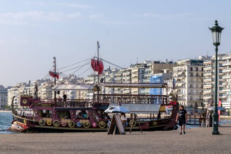 Foto de Tesalónica, Grecia - 22 de septiembre de 2023: Vista de un barco turístico decorado como un antiguo Trireme frente a la Torre Blanca en Tesalónica Grecia - Imagen libre de derechos