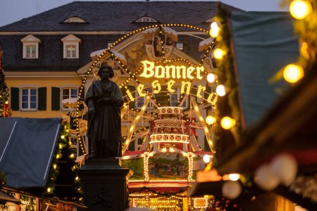 Foto de Bonn, Alemania - 16 de diciembre de 2023: Vista de la estatua de Beethoven y una noria en el mercado de Navidad en Bonn Alemania - Imagen libre de derechos