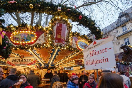 Foto de Bonn, Alemania - 16 de diciembre de 2023: Gente disfrutando de Glhwein, el vino caliente caliente caliente caliente en el tradicional y pintoresco mercado de Navidad en Bonn Alemania - Imagen libre de derechos
