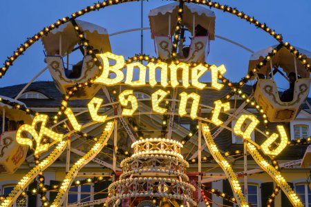 Foto de Bonn, Alemania - 16 de diciembre de 2023: Vista de la noria iluminada en el mercado navideño de Bonn Alemania - Imagen libre de derechos