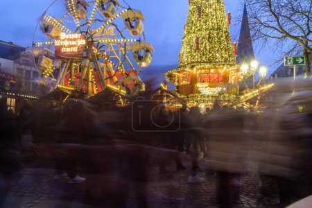 Foto de Bonn, Alemania - 16 de diciembre de 2023: Vista de un árbol de Navidad iluminado y una noria en el mercado de Navidad de Bonn Alemania - Imagen libre de derechos