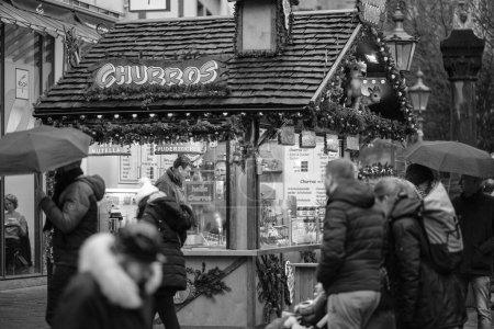 Foto de Bonn, Alemania - 17 de diciembre de 2023: Vista de un pequeño puesto de comida que vende Churros y otros dulces en el Mercado de Navidad de Bonn Alemania - Imagen libre de derechos