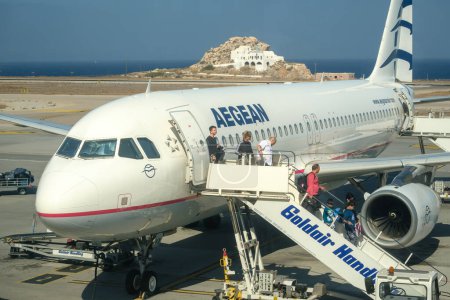 Foto de Santorini, Grecia - 19 de septiembre de 2023: Vista de una avioneta del mar Egeo, que aterrizó hace unos minutos y los pasajeros que utilizan la escalera de aviones para descender en el aeropuerto de Santorini Grecia - Imagen libre de derechos