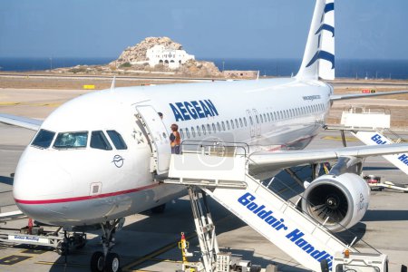 Foto de Santorini, Grecia - 19 de septiembre de 2023: Vista de una avioneta del mar Egeo, que aterrizó hace unos minutos y los pasajeros que utilizan la escalera de aviones para descender en el aeropuerto de Santorini Grecia - Imagen libre de derechos