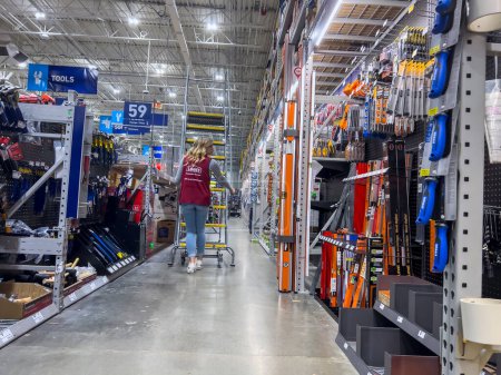Téléchargez les photos : Everett, WA États-Unis - vers septembre 2022 : Vue générale d'un employé de Lowes déplaçant une échelle d'escalier dans le magasin de rénovation domiciliaire. - en image libre de droit