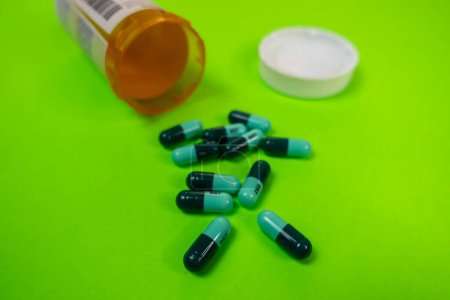 Photo for Seattle, WA USA - circa November 2022: Selective focus on Hydroxyzine pills out of the prescription bottle on a green background. - Royalty Free Image