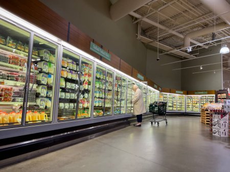Foto de Mill Creek, WA USA - circa December 2022: Wide view of a woman shopping in the refrigerated section of a Town and Country Market. - Imagen libre de derechos