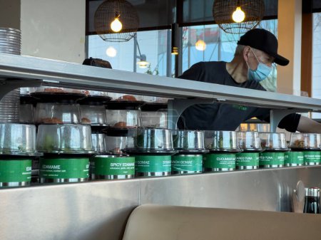 Photo for Lynnwood, WA USA - circa January 2023: Selective focus on fresh sushi on a conveyor belt inside Bitty Fish Japanese restaurant at the Alderwood Mall. - Royalty Free Image