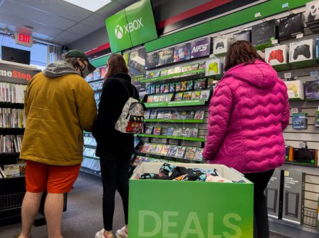 Téléchargez les photos : Seattle, WA USA - circa December 2022: People shopping for used video games inside a GameStop gaming store. - en image libre de droit