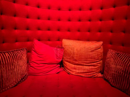 Foto de Amplia vista de almohadas rojas contra un asiento acolchado rojo felpa - Imagen libre de derechos