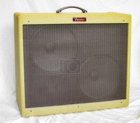 Photo for Old vintage retro style fender guitar tube amp or amplifier yellow tweed design with two large speakers visible behind brown grill cover plate.  Isolated on white sheet background Oct 14, 2023 Florida - Royalty Free Image