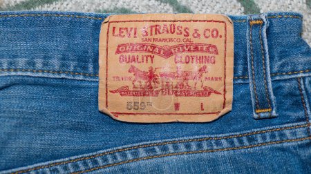 Téléchargez les photos : Ocala, Floride 2-25-2024 Levis Strauss et compagnie originale riveté vêtements de qualité bleu jeans marque 559 gros plan sur patch en cuir avec lettrage rouge sur le dos du pantalon. - en image libre de droit