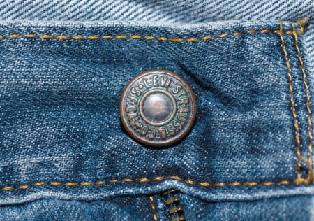 Téléchargez les photos : Ocala, FL 3-2-2024 LS et Co SF CAL Levi Strauss et la société ont breveté le bouton sur la paire standard de jeans en denim Levi. Oxydation du métal en laiton sur une vieille paire de pantalons en jean bleu - en image libre de droit