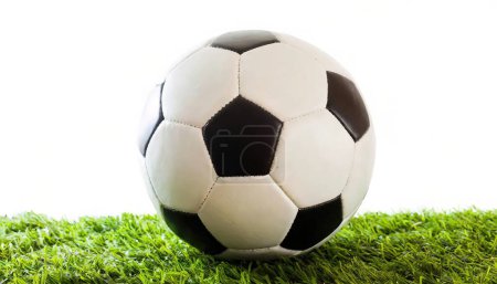 Fußball oder Fußball auf Astroturf Astro Rasen Gras isoliert auf weißem Hintergrund schwarz und weiß Fünfeck Form Lederteile zusammengenäht, um einen runden Ball zu bilden
