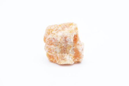 Macro enfocado en naranja vibrante cruda, piedra calcita, gemas de cristal de carbonato naranja brillante aisladas sobre un fondo de superficie blanca. se cree que es una gran piedra para el equilibrio.