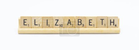 Miami, FL 4-18-24 popular baby girl first name of ELIZABETH made with square wooden tile English alphabet letters with natural color and grain on a wood rack holder isolated on white background