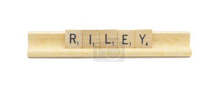Miami, FL 4-18-24 popular baby girl first name of RILEY made with square wooden tile English alphabet letters with natural color and grain on a wood rack holder isolated on white background