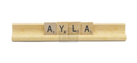 Miami, FL 4-18-24 popular baby girl first name of AYLA made with square wooden tile English alphabet letters with natural color and grain on a wood rack holder isolated on white background