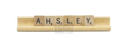 Miami, FL 4-18-24 popular baby girl first name of ASHLEY made with square wooden tile English alphabet letters with natural color and grain on a wood rack holder isolated on white background