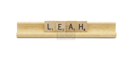 Miami, FL 4-18-24 popular baby girl first name of LEAH made with square wooden tile English alphabet letters with natural color and grain on a wood rack holder isolated on white background