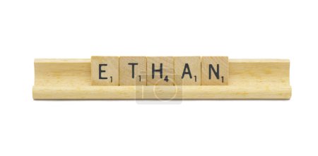 Miami, FL 4-18-24 popular baby boy first name of ETHAN made with square wooden tile English alphabet letters with natural color and grain on a wood rack holder isolated on white background