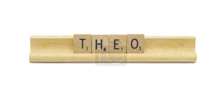 Miami, FL 4-18-24 popular baby boy first name of THEO made with square wooden tile English alphabet letters with natural color and grain on a wood rack holder isolated on white background