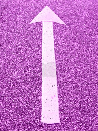 Foto de Una flecha blanca sobre una superficie rosa señalando el camino a seguir - Imagen libre de derechos