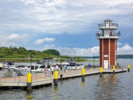Foto de Plau am See, Mecklemburgo-Pomerania Occidental, Alemania - 13 de julio de 2016: Turistas en el concurrido puerto con torre de observación - Imagen libre de derechos