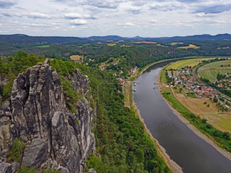 Foto de Vista desde la formación rocosa Bastei hasta el pueblo de Rathen y el Elba en la Suiza sajona, Alemania - Imagen libre de derechos