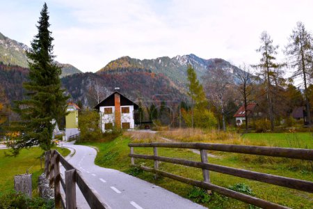 Téléchargez les photos : Piste cyclable dans le village de Gozd Martuljek à Gorenjska, Slovénie et chaîne de montagnes dans les montagnes de Karavanke en automne - en image libre de droit
