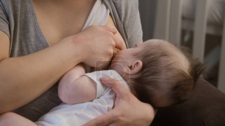 Nahaufnahme einer stillenden Mutter. Frau hält Baby beim Füttern auf den Arm, schläft ein Kleines Kind saugt Muttermilch. Konzept von Kindheit, Mutterschaft, Liebe und Familie.