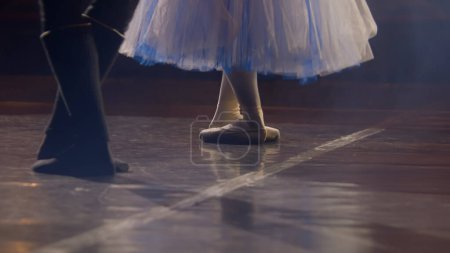 Téléchargez les photos : Gros plan des jambes des danseurs de ballet qui s'entraînent sur scène pendant la répétition chorégraphique. L'homme et la femme se préparent à la performance, à la danse et au ballet. Art de la danse classique. - en image libre de droit