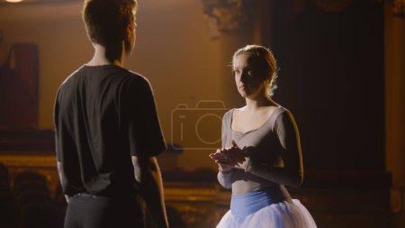 Téléchargez les photos : De beaux danseurs de ballet s'entraînent sur scène lors de répétitions chorégraphiques. Homme et femme se réchauffent et se préparent pour la danse théâtrale. Art de la danse classique. Éclairage dramatique. - en image libre de droit