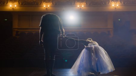 Photo for Ballet dancers bowing during choreography rehearsal on classic theater stage illuminated by spotlight. Man and woman prepare theatrical dance performance. Art of classical ballet dance. Slow motion. - Royalty Free Image