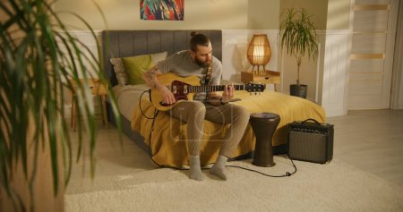 Téléchargez les photos : Homme joue de la guitare dans la chambre. - en image libre de droit