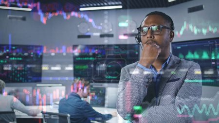 Téléchargez les photos : African American investment specialist analyse les stocks en temps réel en fonction. Graphiques 3D de graphiques crypto-monétaires sur paroi de verre. Animation futuriste VFX. Les employés travaillent sur des ordinateurs en arrière-plan. - en image libre de droit