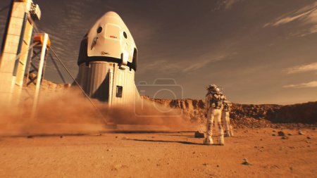 Téléchargez les photos : Deux astronautes en combinaison spatiale se tiennent debout, regardant des engins spatiaux atterrir sur Mars. Mission spatiale habitée sur la planète rouge. Progrès technologique de l'avenir. Concept futuriste de colonisation et d'exploration. - en image libre de droit