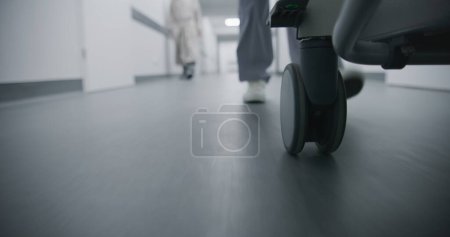 Photo for Doctor, nurse or paramedic move gurney with seriously injured patient towards surgery room. Medic save human life. Medical staff legs close up. Bright medical facility corridor. Emergency department. - Royalty Free Image