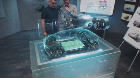 Téléchargez les photos : Deux ingénieurs automobiles masculins développent une nouvelle voiture électrique écologique en utilisant un prototype d'automobile holographique futuriste à réalité augmentée. Graphiques 3D de véhicule high-tech en développement. Animation VFX. - en image libre de droit
