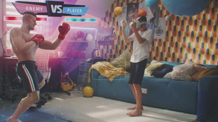 Téléchargez les photos : Boy in VR casque joue en ligne réalité augmentée jeu vidéo à la maison en utilisant des contrôleurs sans fil. Jeune joueur se bat avec hologramme graphique 3D de boxeur. Animation futuriste VFX. Concept de jeu virtuel. - en image libre de droit