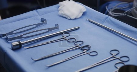 Photo for Close up shot of table with professional surgical instruments in surgery. Medical personnel do heart transplantation to seriously ill patient in operating room. Medics work in modern medical facility. - Royalty Free Image