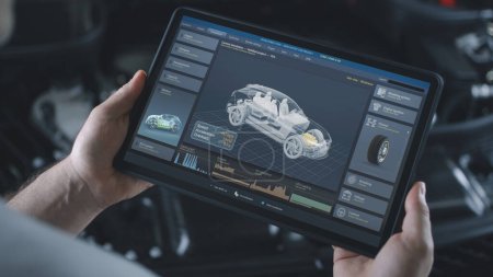 Téléchargez les photos : Homme technicien détient ordinateur tablette numérique. Simulation des diagnostics de voiture en temps réel et des tests aérodynamiques affichés à l'écran. Animation 3D de logiciels avec modèle de véhicule électrique virtuel 3D. - en image libre de droit