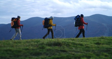 Photo for Full shot of African American man with Caucasian woman walking along trail in mountains in autumn. Multiethnic couple of tourist during trek or expedition to mountains on vacation. Active leisure. - Royalty Free Image